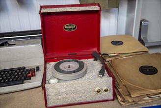 A Dansette Popular mono portable record player on sale at auction next to 78 rpm records