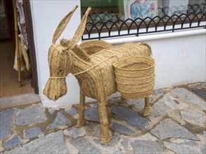 Woven reed mule or donkey product on sale at souvenir shop in village of Mojacar, Almeria, Spain,
