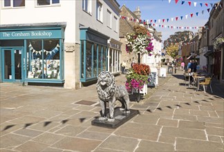 Lion sculpture in historic street and buildings in town centre of Corsham, Wiltshire, England, UK