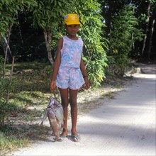 Girl carrying fish on the island of La Digue, Seychelles, Africa
