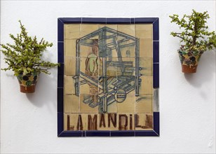 Close up of ceramic tile sign for textile workshop outside bar restaurant, Nijar, Almeria, Spain,