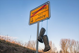 Freimersheim, Palatinate: Upside-down town sign with rubber boots as a symbol of the farmers'