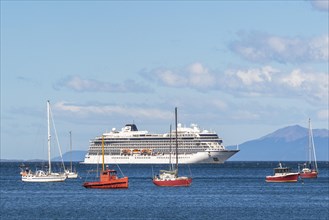 Yachts and fishing boats anchored in front of a cruise ship in the harbour on the Beagle Channel,