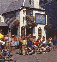 People in front of The Sloop Inn pub, England's oldest pub dating back to 1312, in St Ives,