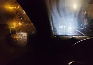 View from the car in dangerously poor visibility at night with rain and blinding backlight,