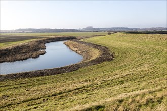 Drainage channel lowland fields inland from flood defence dyke wall, River Deben valley, Falkenham,