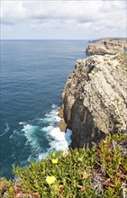 Sheer cliffs rise from Atlantic Ocean at Cabo de Sao Vicente, Cape St Vincent, Algarve, Portugal