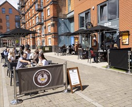 People sitting outside newly reopened cafes on the waterfront, Wet Dock, Ipswich, Suffolk, England,