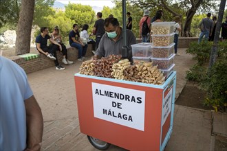 Trader selling roasted almonds outside Castillo de Gibralfaro castle, Malaga, Andalusia, Spain,