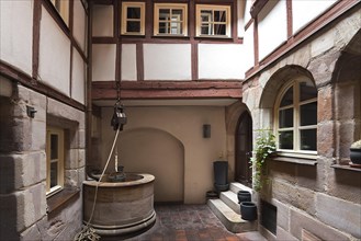 Medieval draw well in an old courtyard in the historic city centre, Nuremberg, Middle Franconia,