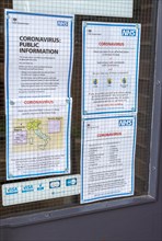 National Health Service NHS government information Coronavirus notice glass door entrance to GP