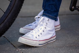 Woman wears white chucks and jeans