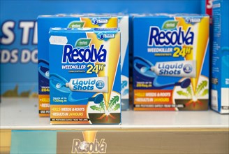Cardboard boxes of Resolva weedkiller liquid shots 24 hour concentrate on shelf display in garden