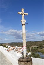 Historic cross crucifixion of Jesus Christ monument in medieval village with the Latin word