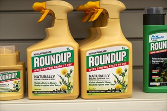 Plastic containers Roundup no Glyphospahte weed killer spray on shelf display in garden centre, UK