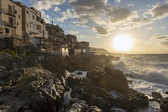 Sea water crashes against the cliffs of the rugged coastline in the town of Cefalu, Sicily, Italy,