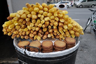 Reiberdatschi or fried potato pancakes beside fried potato slices at an outdoor stall on a cold