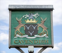 Village sign coat of arms heraldry, Cavendish, Suffolk, England, UK
