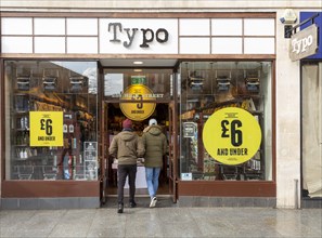 Sale at Typo store in city centre High Street shop, Exeter, Devon, England, UK, two people entering