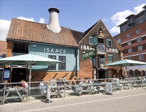 People sitting outside newly reopened Isaacs pub on the waterfront, Wet Dock, Ipswich, Suffolk,