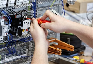 An electronics apprentice assembles a motor protection relay at a Deutsche Bahn training centre,