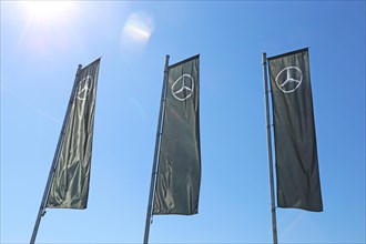 Flag with the Mercedes-Benz star against a blue sky