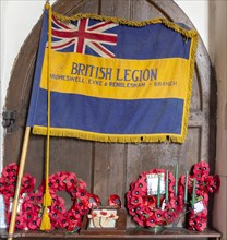 Village parish church All Saints, Eyke, Suffolk, England, UK, British Legion flag banner