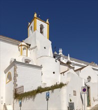 Whitewashed exterior walls and tower of Roman Catholic church Igreja de Santiago, Tavira, Algarve,