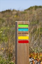Footpath marker way mark sign painted in green, blue, yellow and red stripes for the Ruta Vicentina