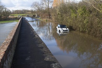 Mini Cooper S car stuck in River Avon flood water, Kellaways bridge, Wiltshire, England, UK