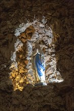 Statue of Blessed Virgin Mary standing in rock grotto ichurch of Igreja de Santiago, Tavira,