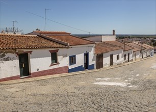 Traditional street of small Portuguese whitewashed cottage houses, Mourao, Alentejo Central, Evora