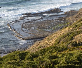 Intensely folded rock of wave cut platform. Rocky rugged coastal landscape on the Rota Vicentina