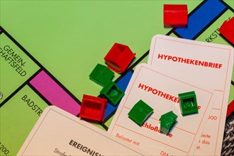 Symbolic image of real estate: Monopoly game with toppled houses and mortgage bonds