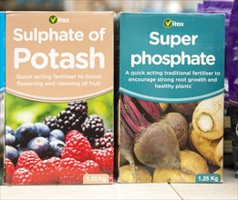 Cardboard boxes of Vitax Sulphate of Potash and Super Phosphate on shelf display in garden centre,