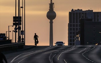 A cyclist and a car driver ride alone on the otherwise busy Frankfurter Allee, Berlin, 29/03/2021