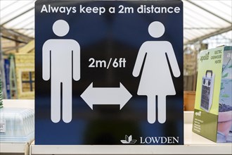 Social Distancing 2 metres apart information notice sign in Lowden garden centre shop, Wiltshire,