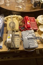 Old telephones on display in house clearance auction sale room, UK