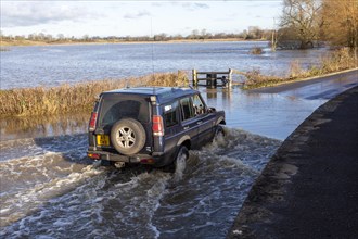 Land Rover Discovery Td5 vehicle driving through flood water at Kellaways, Wiltshire, England, UK