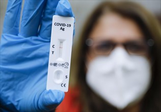 A woman with FFP2 mask shows a negative Corona rapid test, Berlin, 11.03.2021