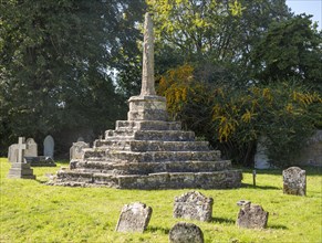 Medieval churchyard standing cross and ancient gravestones, Chew Magna, Somerset, England, UK