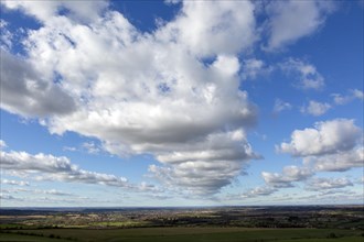 Lines of cumulus clouds in blue sky passing over countryside, Calne, Wiltshire, England, UK