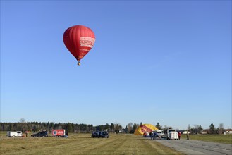 Hot air balloon in the colour red starts at the airfield, Montgolfiade Tegernseer Tal, Balloon Week