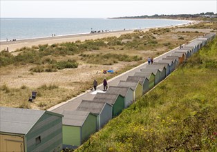 Coastline in summer sandy beach and beach huts, Pakefield, Lowestoft, Suffolk, England, UK