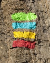 Footpath marker way mark sign painted in green, blue, yellow and red stripes for the Ruta Vicentina