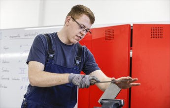 A trainee mechatronics technician works on a workpiece at a Deutsche Bahn training centre, Berlin,