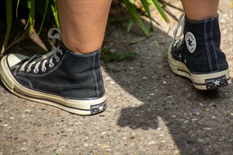 Close-up of black Chucks, worn by a young woman