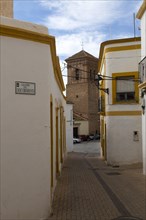 Parish church at end of narrow street of old historic houses in historic village of Nijar, Almeria,