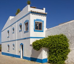 Traditional architecture building style house with whitewashed walls and blue painted features,