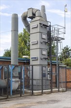 Exhaust gas air purification tower at small specialist steel firm, Calne, England, UK